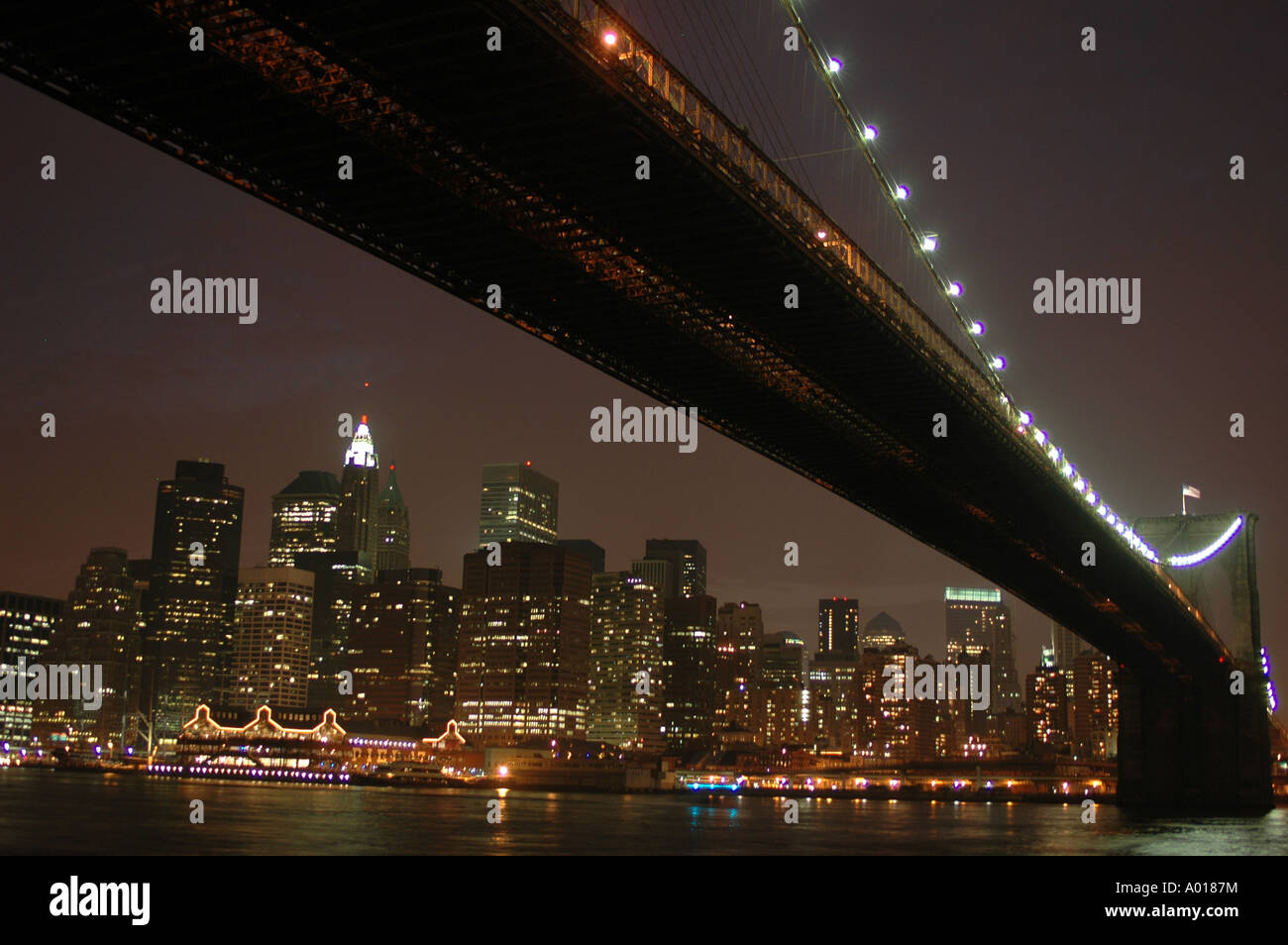 NYC Sonnenuntergang unter der Brooklyn Bridge am 4. Juli mit dem Zwielicht mit Blick auf Downtown Manhattan und South Street Seaport Stockfoto