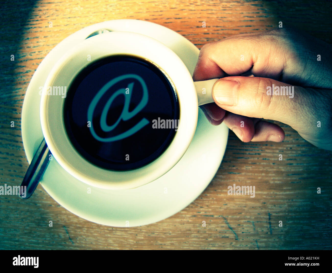 Draufsicht auf der Hand, die eine Kaffeetasse mit e-Mail-Symbol in Stockfoto