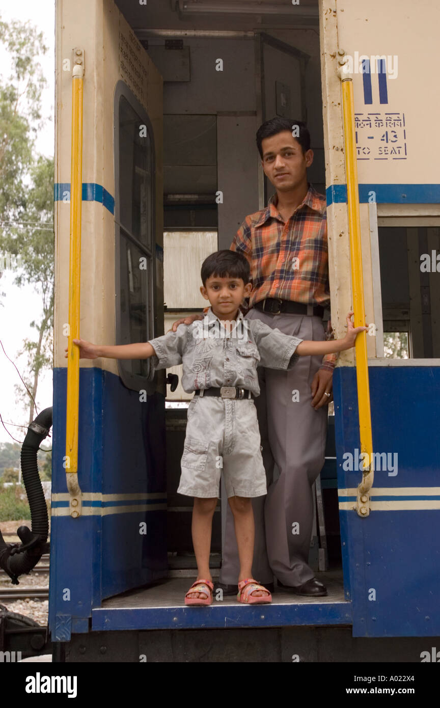 Indischer Vater und Sohn stehen in der Tür des Kangra Spielzeugzugs in Himachal Pradesh, Indien. Stockfoto