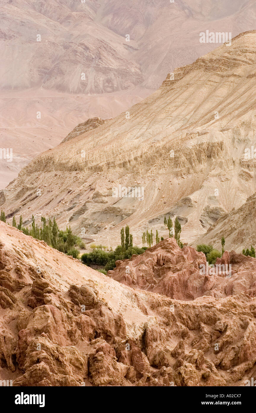 Rötliche Märchen Felsformationen in der Nähe von Basgo Schloss mit Grünpflanzen im Indus-Tal und die Berge in Ladakh Indien backgroundin Stockfoto