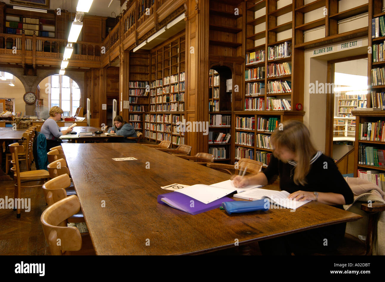 Drei Studenten sitzen in großen Holztischen in der Bibliothek der alten College Aberystwyth Universität Wales UK Stockfoto