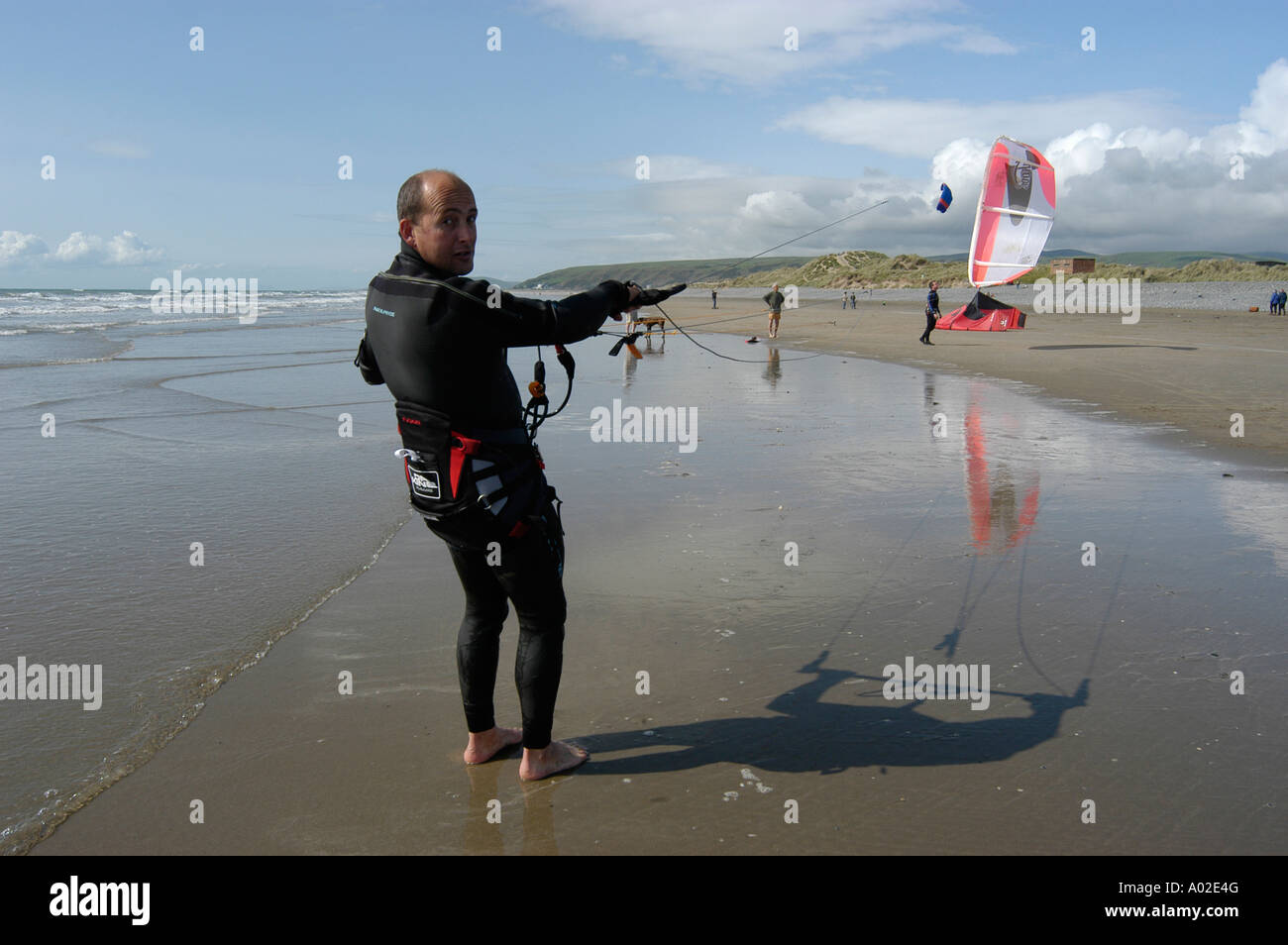 Ynyslas Strand Borth Cardigan Bay West Wales Sommer Nachmittag Mann mit Power Kite Neoprenanzug Extremsport tragen Stockfoto