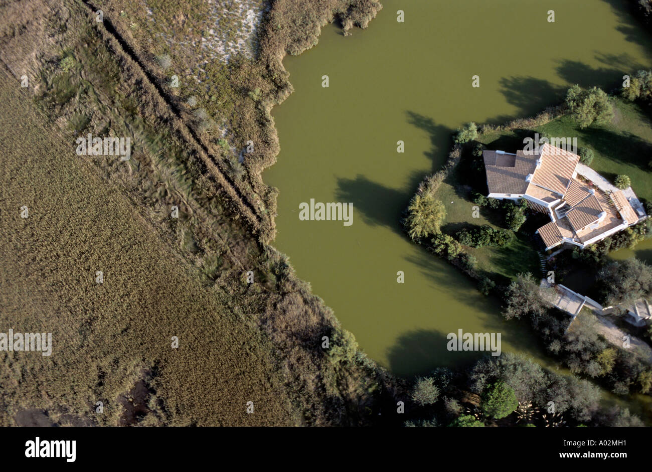 Privathaus liegt am Ufer eines Flusses in Saintes-Maries-de-la-Mer, Camargue, Frankreich. Stockfoto