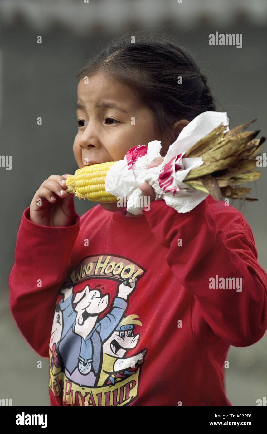 Native American Indian Girl essen Ohr von Mais zu einem County Fair Stockfoto