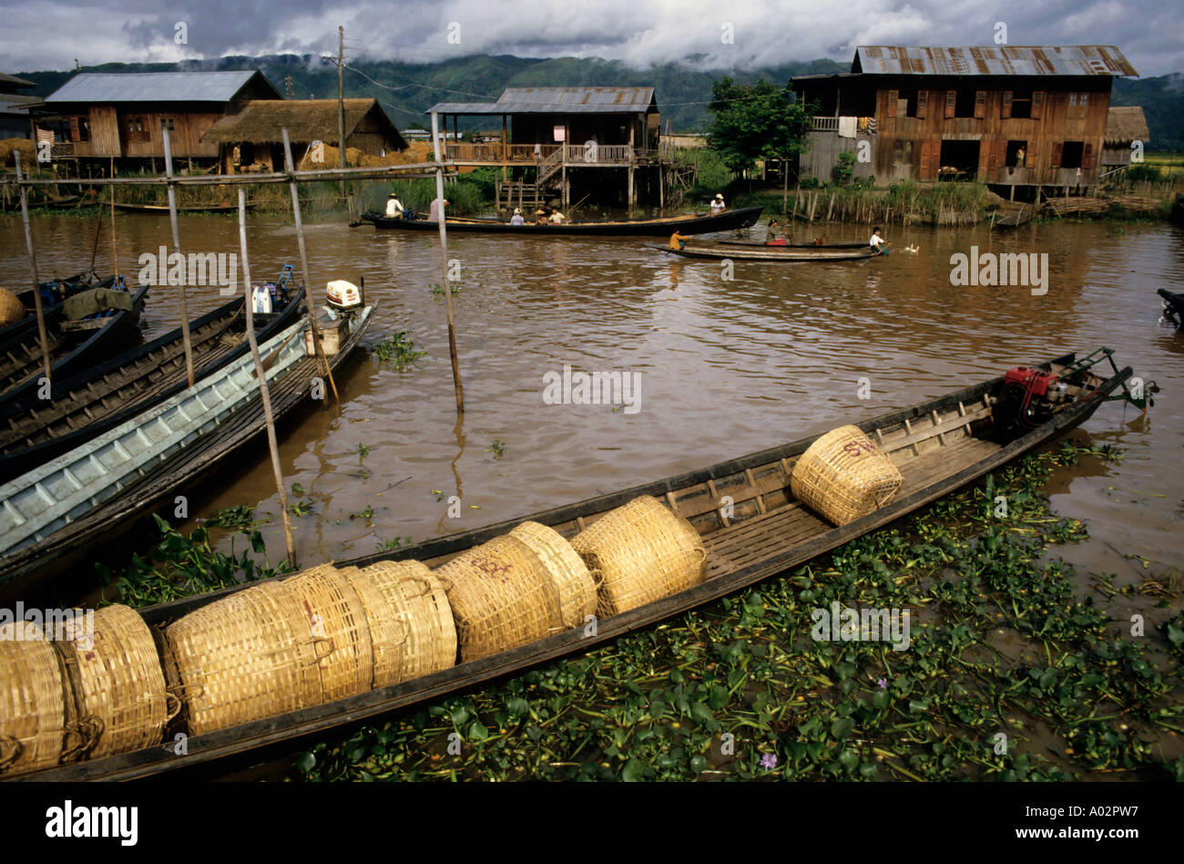 Häuser und traditionelle Boote beladen mit leeren Weidenkörbe, Inle-See, Burma / Myanmar Stockfoto
