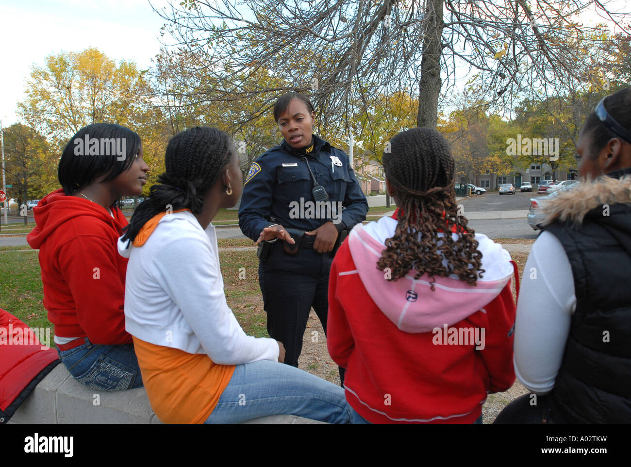 City Polizist im Gespräch mit Jugendlichen in einer Innenstadt-Wohnprojekt Stockfoto