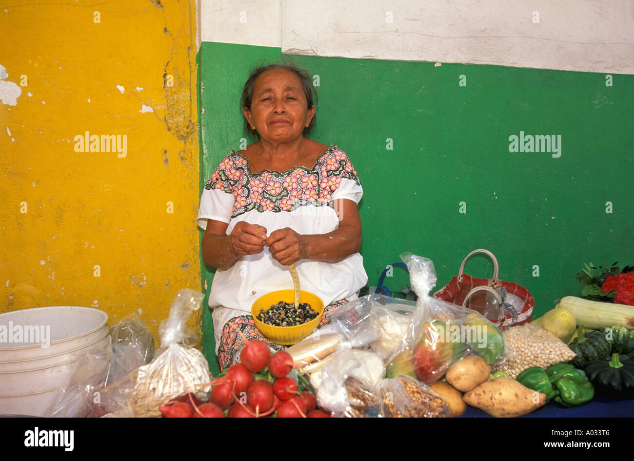 Mexico Maya Frau am Markt Maya produzieren Gemüse Tomaten Yucatan bunte Wand bunten Kostüm Tracht Stockfoto