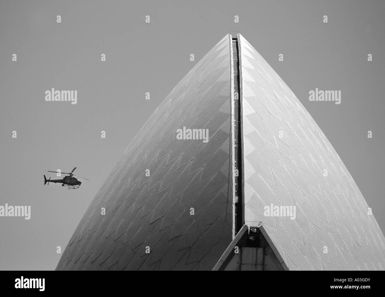 Das Sydney Opera House mit einem Tourismus-Hubschrauber am Himmel hinter Stockfoto