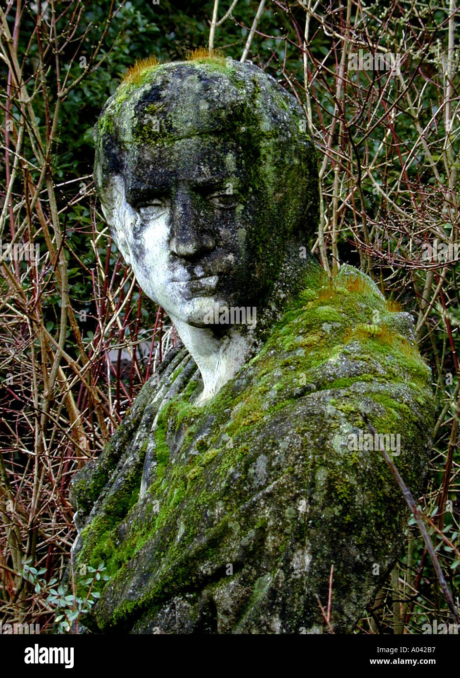 Stein-Statur in Moos und Algen bedeckt Stockfoto