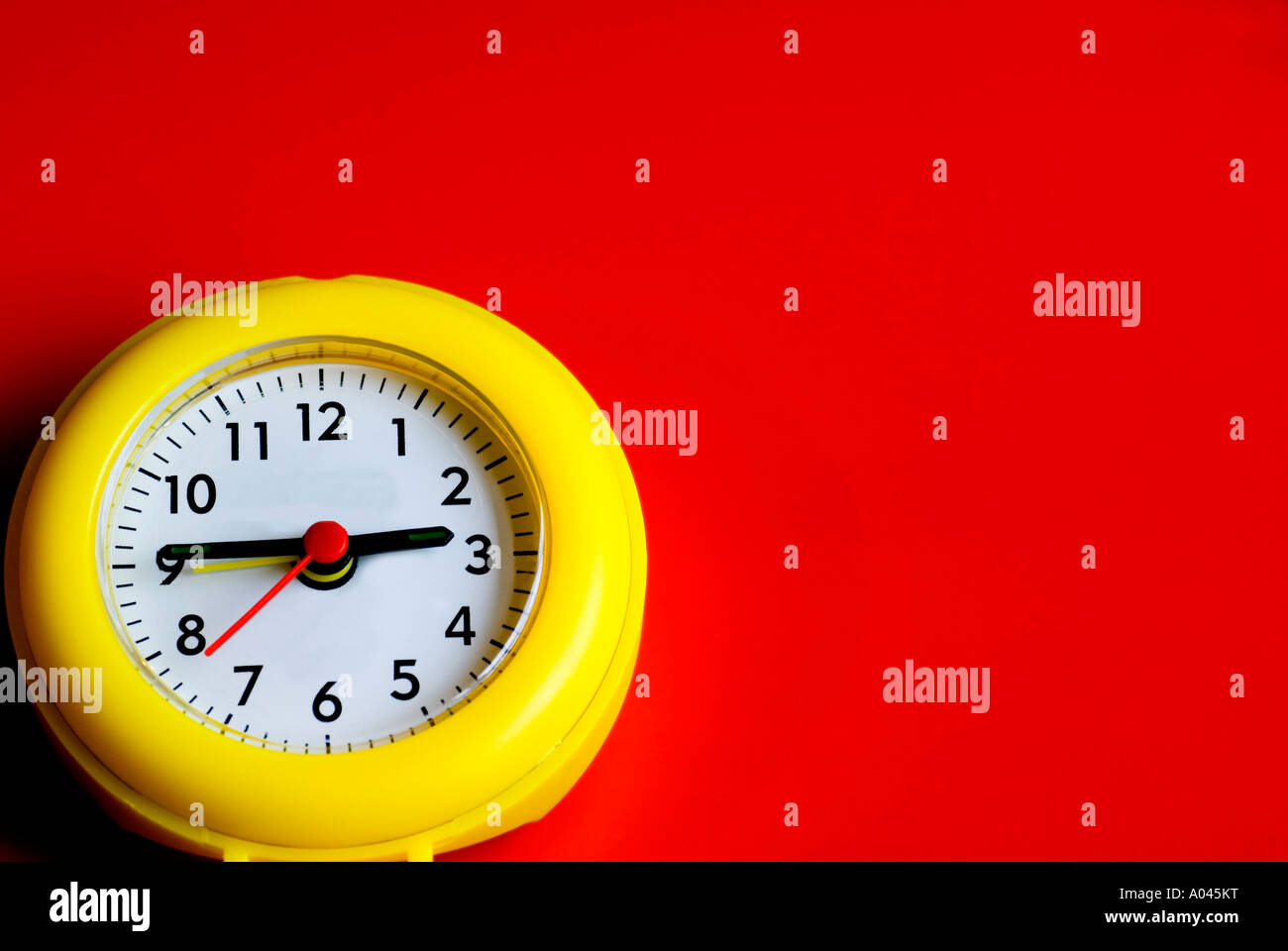 Gelbe Uhr auf rotem Grund Stockfoto