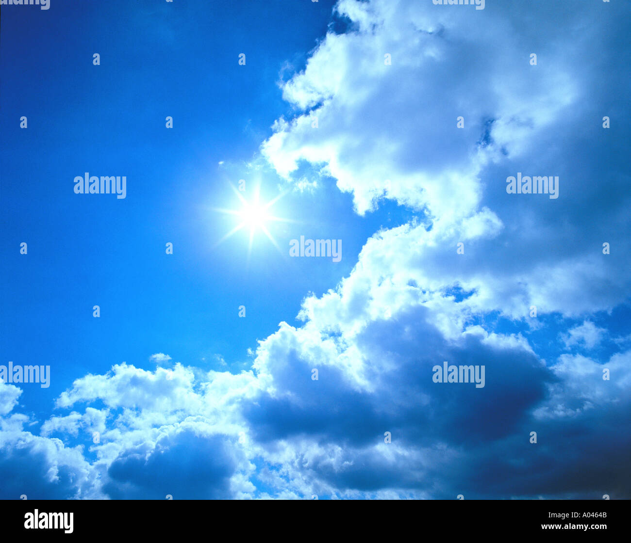 Sunburst und Wolken vor blauem Himmel Stockfoto