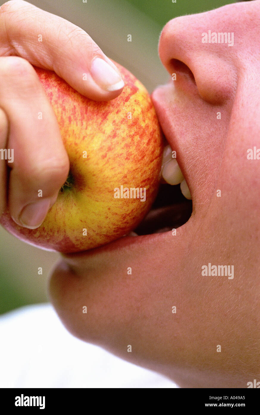 Nahaufnahme einer Frau in einen Apfel beißen Stockfoto