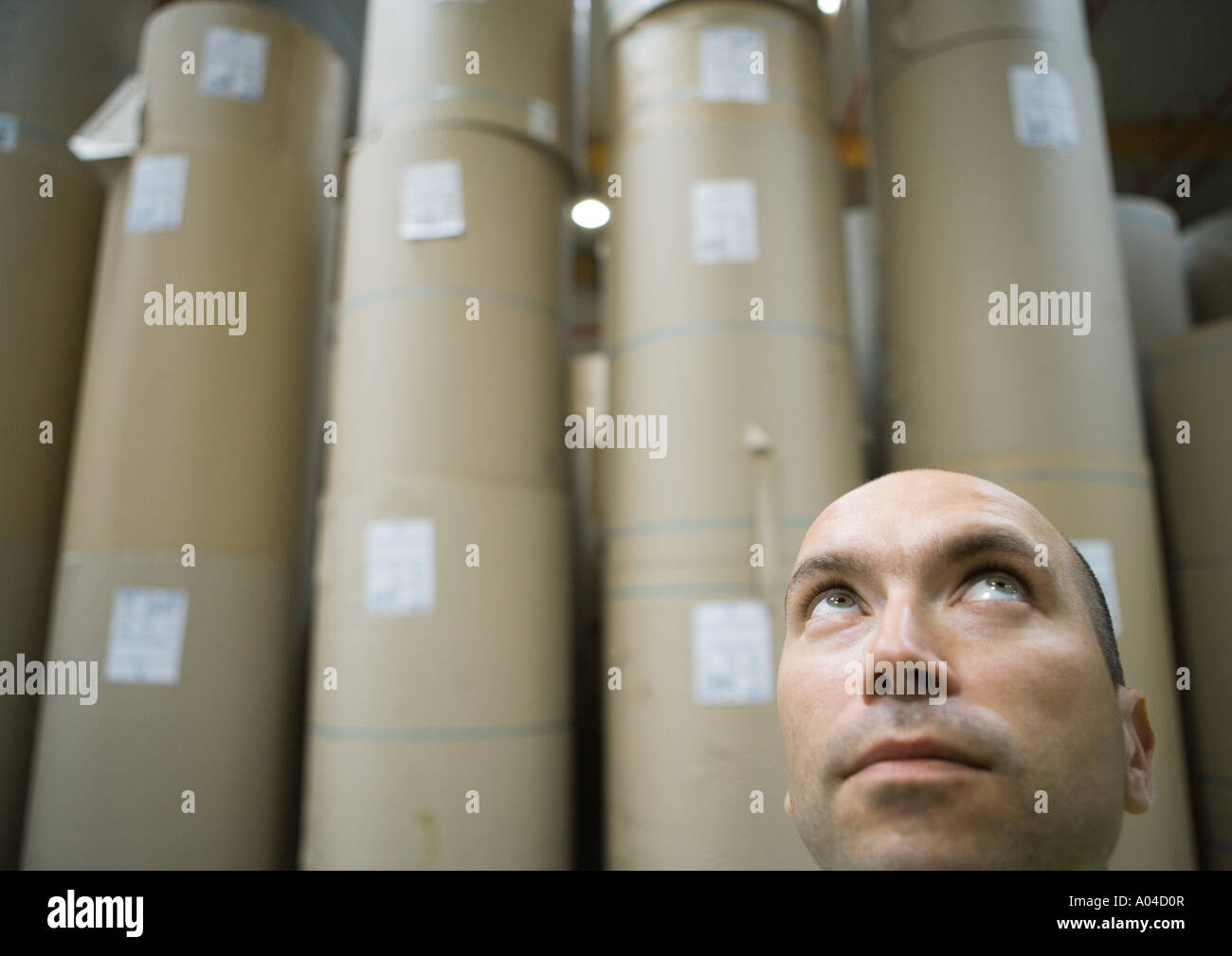 Mann vor Papierrollen im Lager Stockfoto