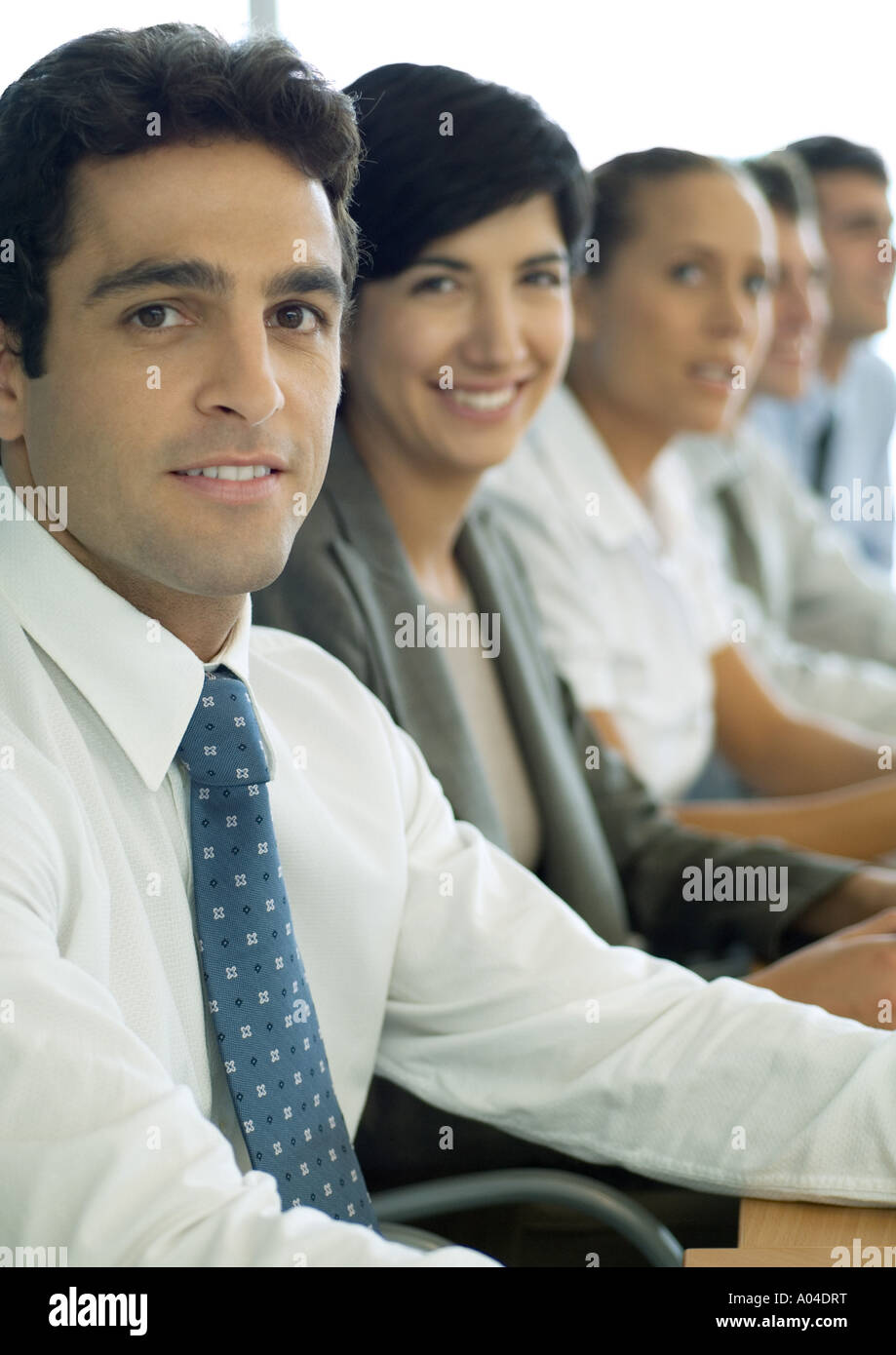Business Partner sitzen in Reihe, konzentrieren sich auf Menschen im Vordergrund Stockfoto
