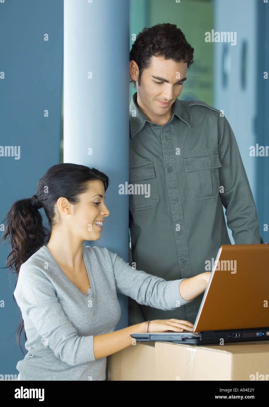 Junge Geschäftsleute mit Laptop auf Karton Stockfoto