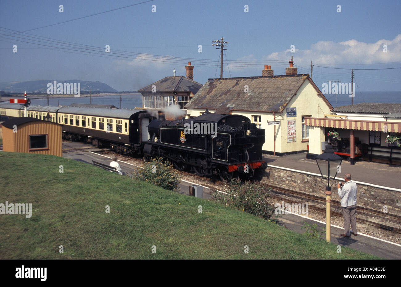 Blue Anchor Seaside Village Bahnhof & bewahrt West Somerset Railway Dampfmaschine 4160 & Zug Ankunft am Bahnsteig Somerset England UK Stockfoto