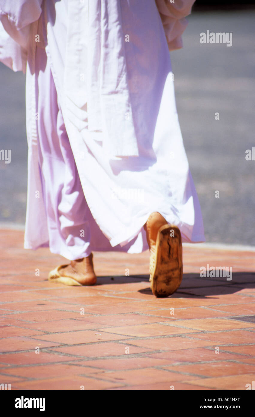 Asiatin in Flip-Flops tragen traditionelle Gewänder zu Fuß auf rotem Pflaster. Stockfoto