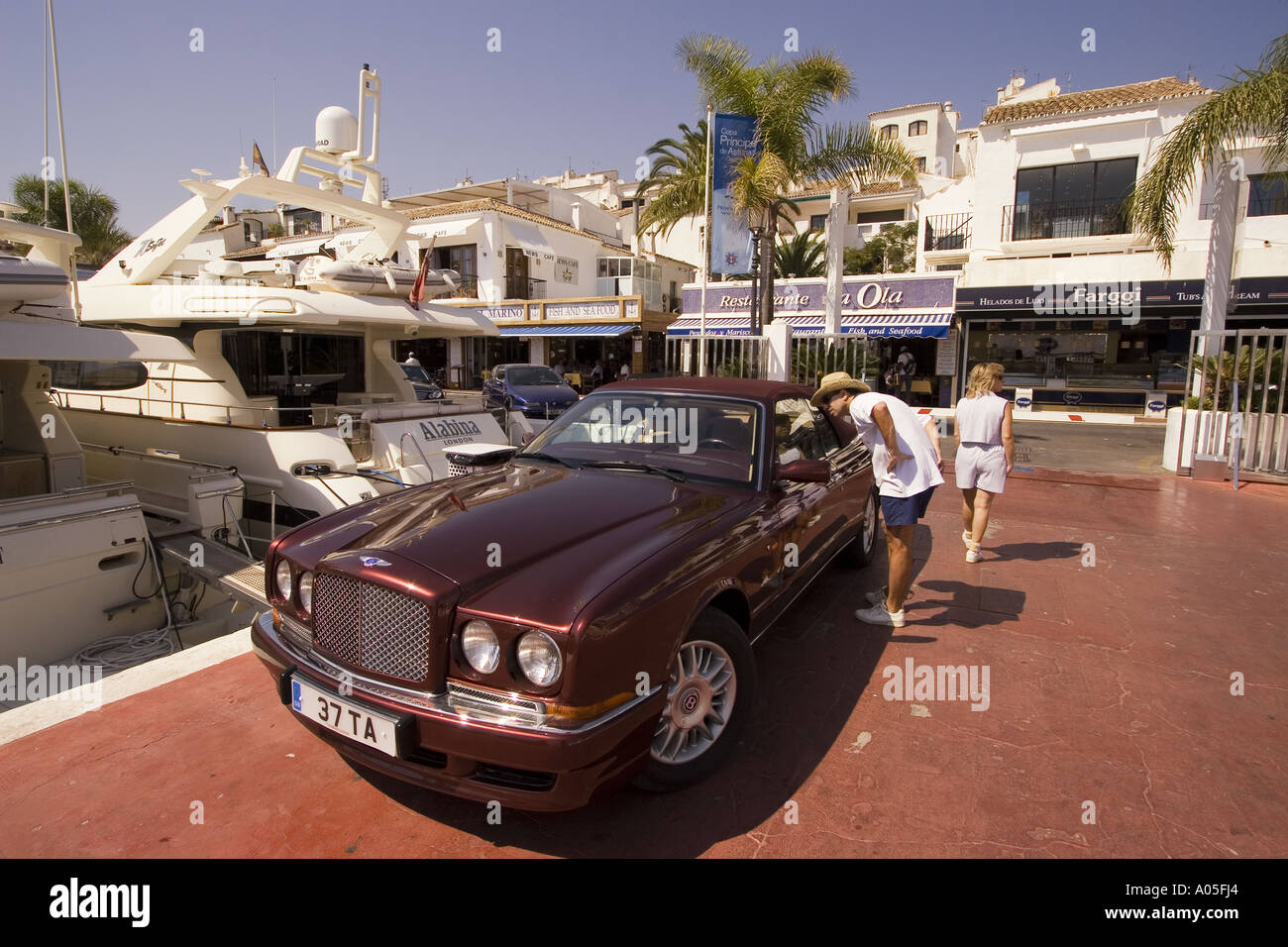 Spanien Puerto Banus Marbella Andalucia Bentley vor Luuxery Yachten Stockfoto