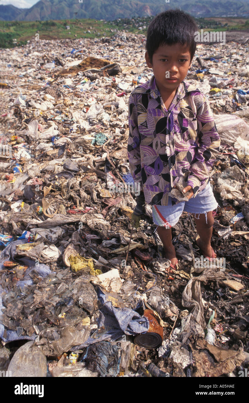 Armer Junge Aufräumvorgang auf der Müllkippe der Stadt für genießbare Lebensmittel Reste und Abfälle Kunststoffartikel in Manila Philippinen zu verkaufen Stockfoto