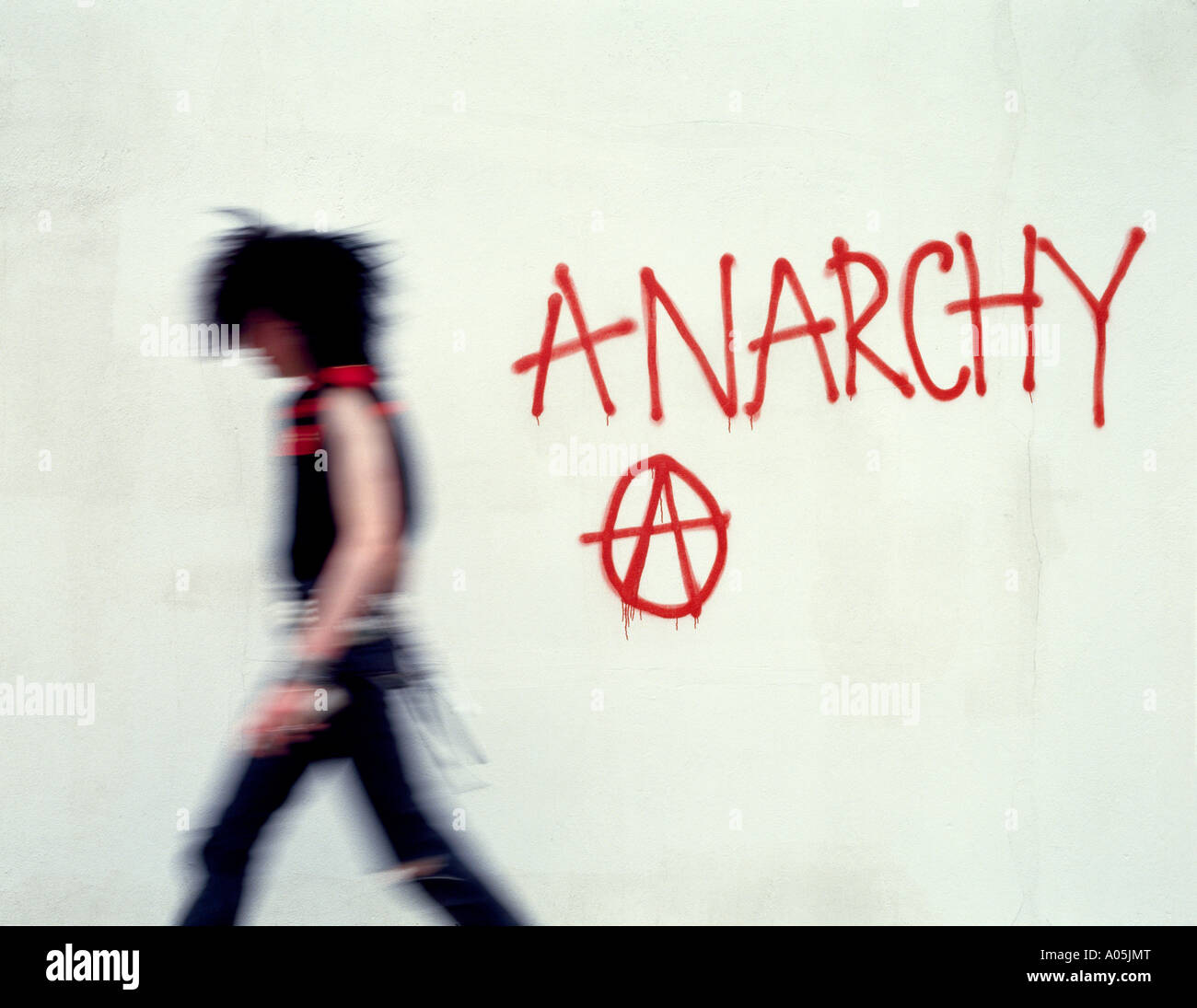 Punk Art Charakter zu Fuß entfernt von sprühen Graffiti an der Wand Stockfoto