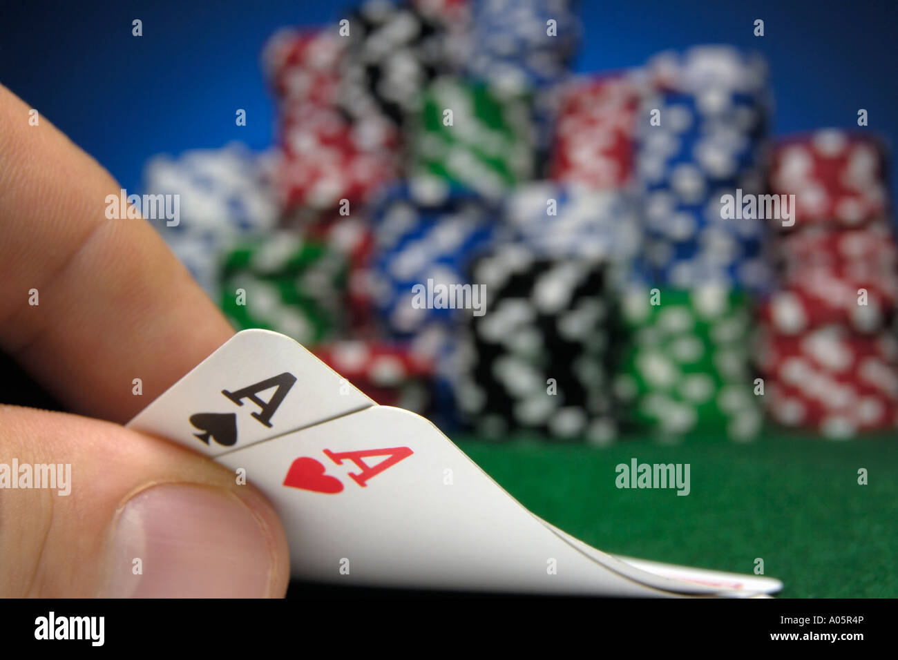 Hand halten zwei Asse mit Poker-chips im Hintergrund Stockfoto