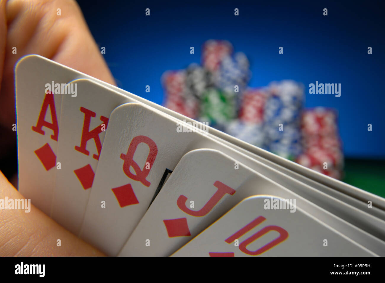 Hand halten Royal Flush in Diamanten mit Poker-chips in den Hintergrund Stockfoto