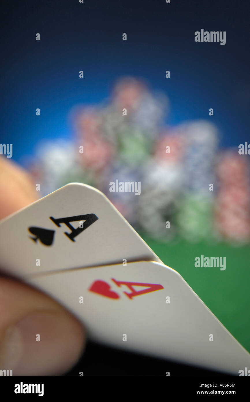 Hand halten zwei Asse mit Poker-chips im Hintergrund Stockfoto
