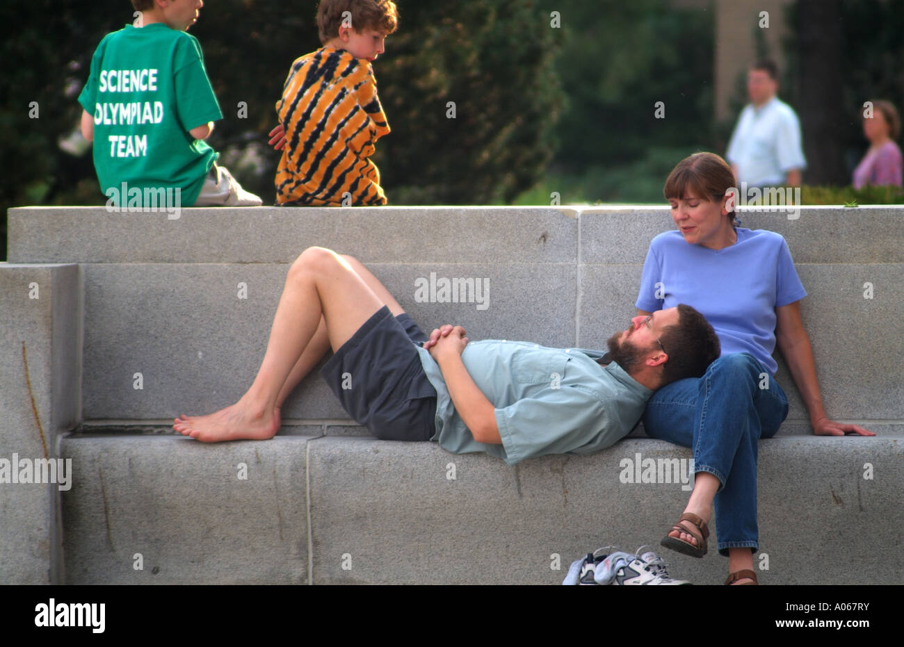 Man ruht auf einer konkreten Bank während im Freien Konzert - Ann Arbor, MI Stockfoto