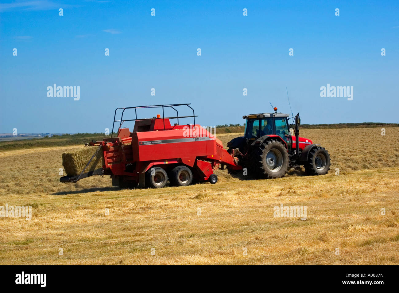 ein Bauer mit einem Traktor Heu Ballen Stockfoto