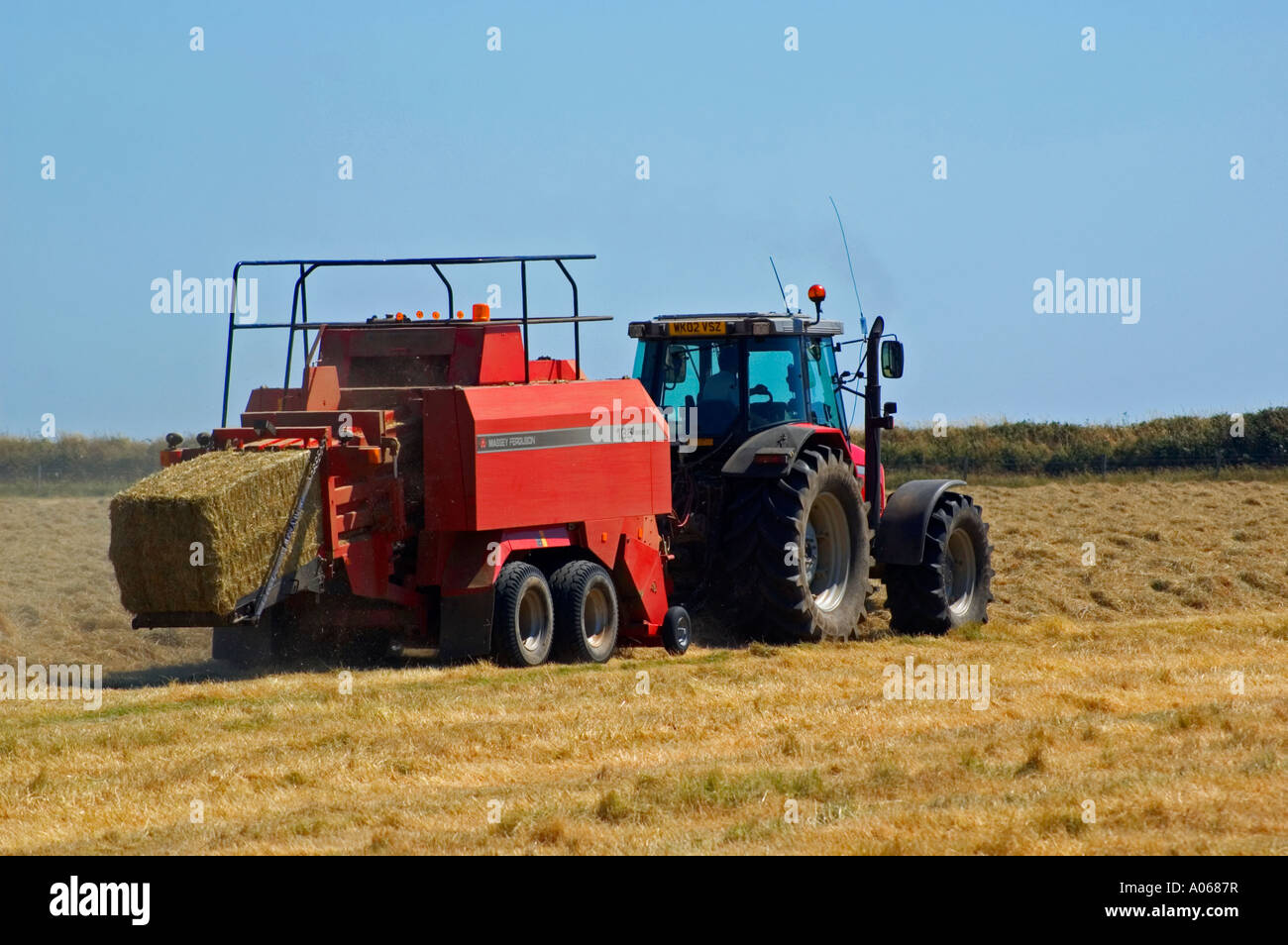 ein Bauer mit einem Traktor Heu Ballen Stockfoto