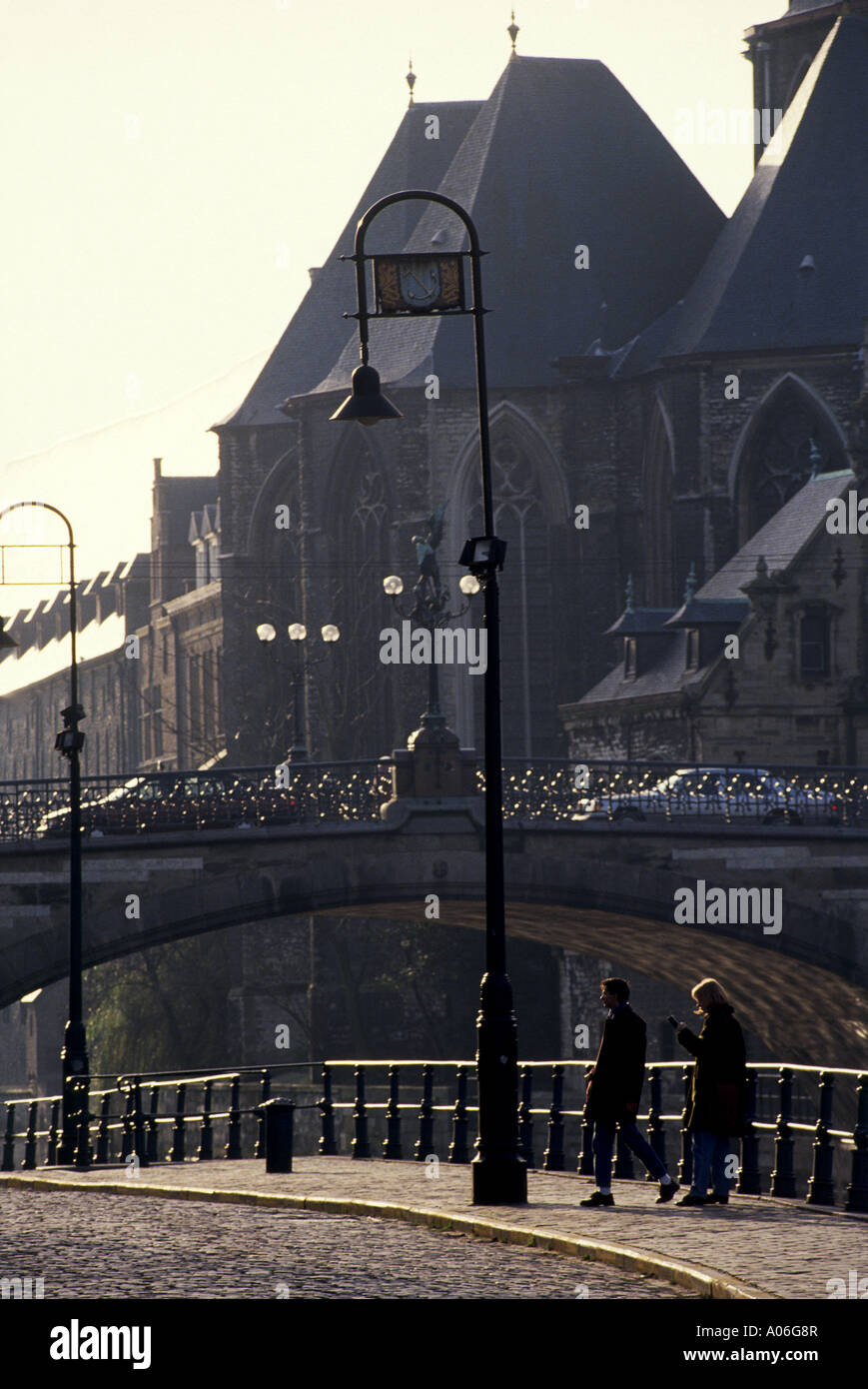 Menschen zu Fuß über eine Brücke unter alten Lampe Standards neben einigen der alten Gebäude in der alten Stadt und großen Meer Hafen von Gent Stockfoto
