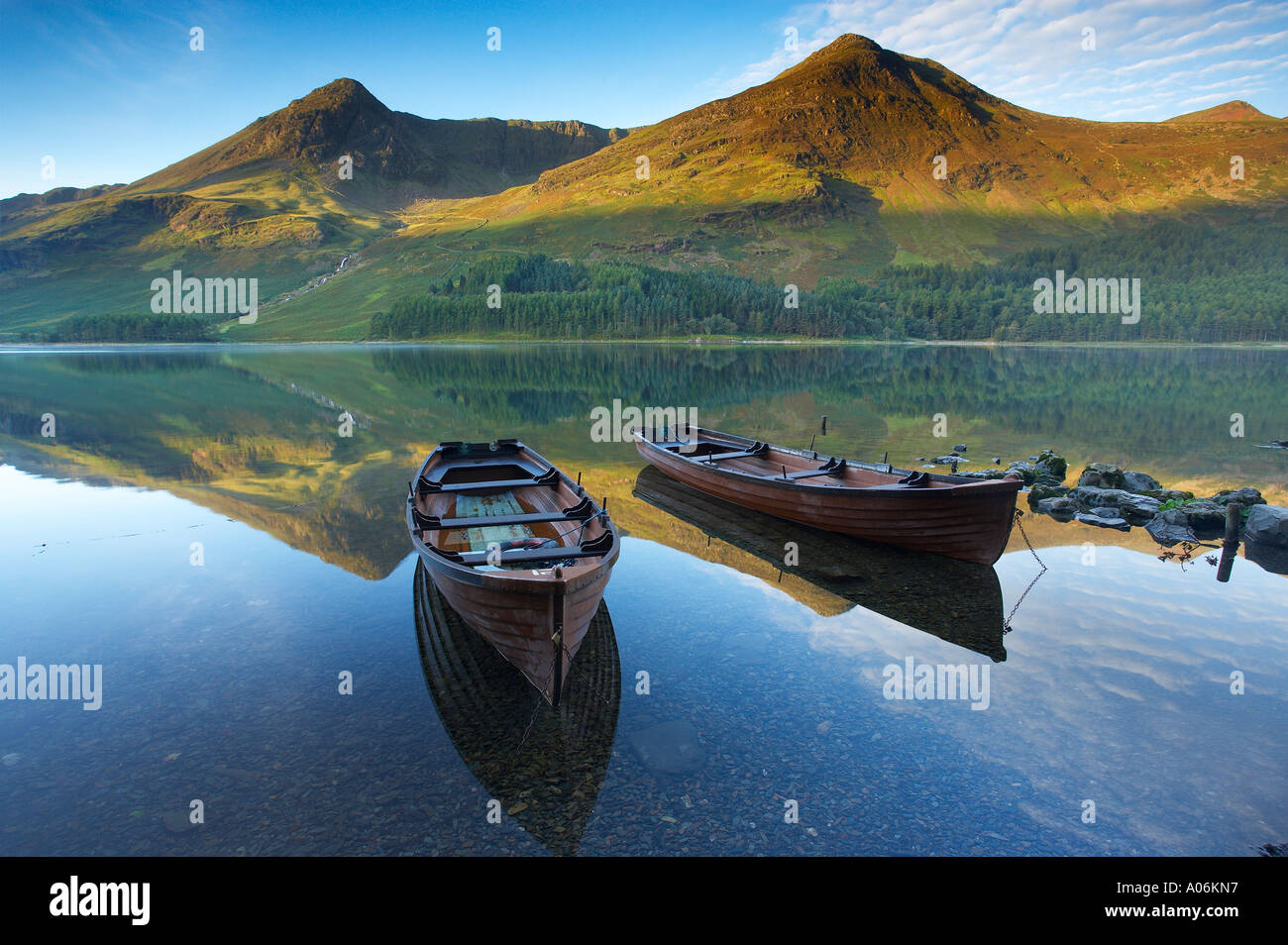 Boote am Ufer Buttermere im Morgengrauen Cumbria Lakes Distrikt Cumbria England UK Stockfoto