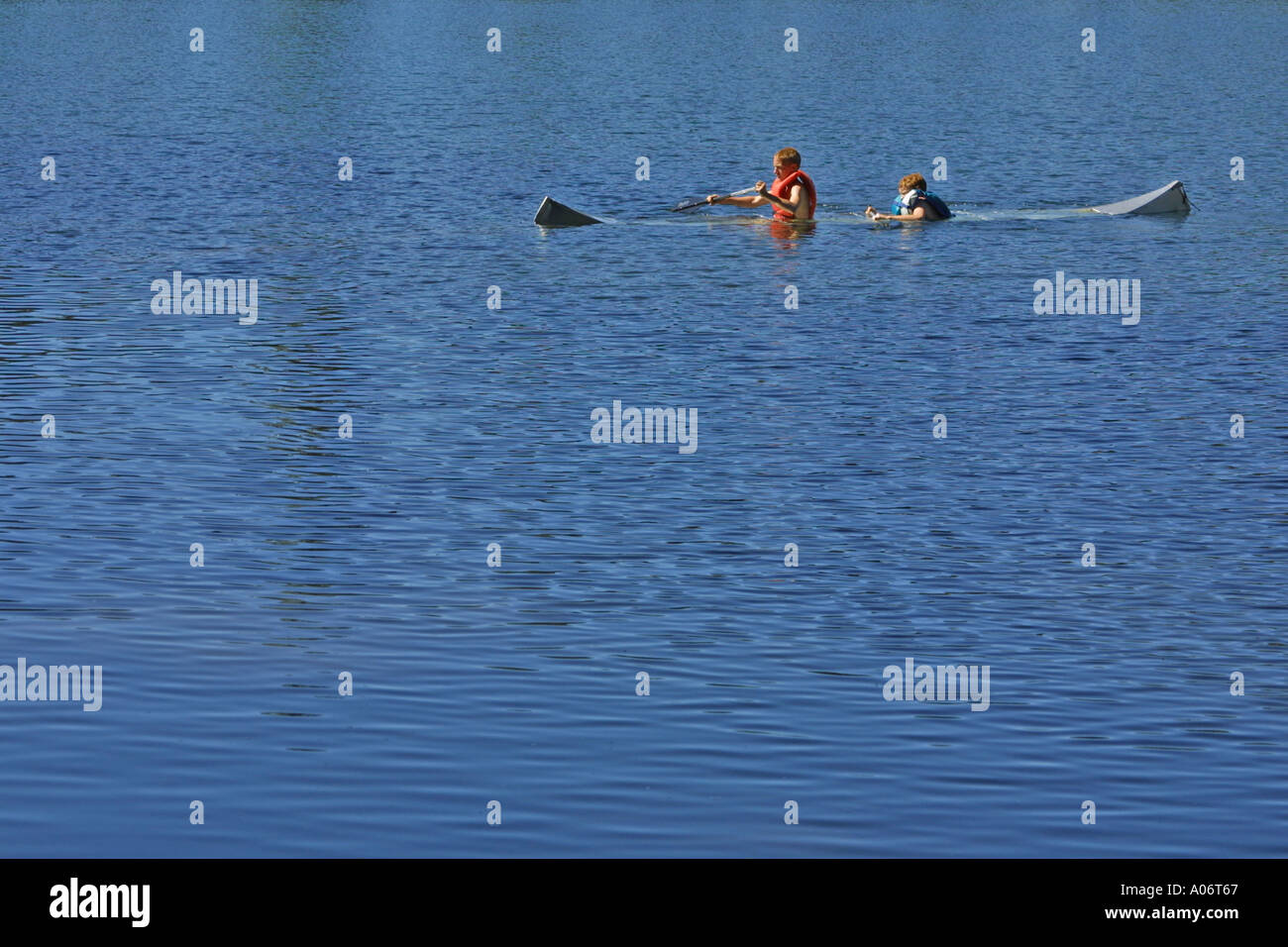 Üben Sie Kanu fahren mit dem Kanu voller Wasser für einen Verdienst-Abzeichen Stockfoto