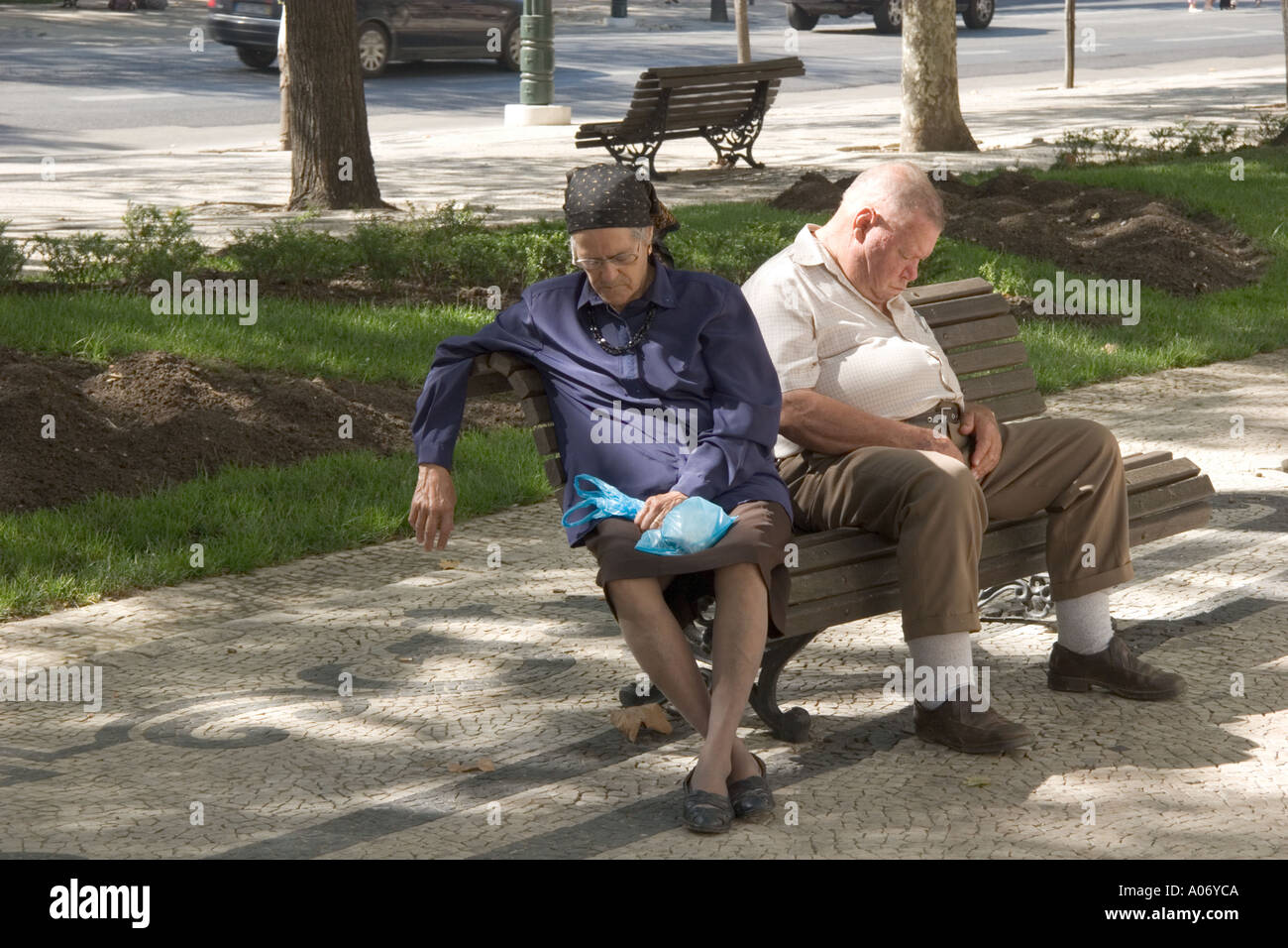 Lissabon Portugal alte paar Übernahme Siesta auf Parkbank in Avenida da Liberdade Stockfoto