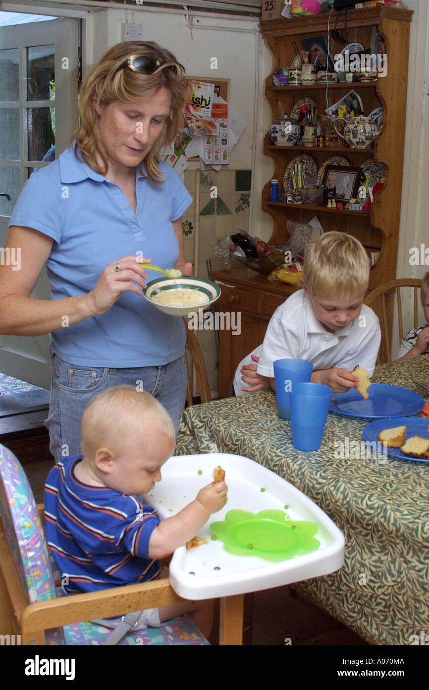 Mutter füttert ihr Kinder Mittagessen Stockfoto