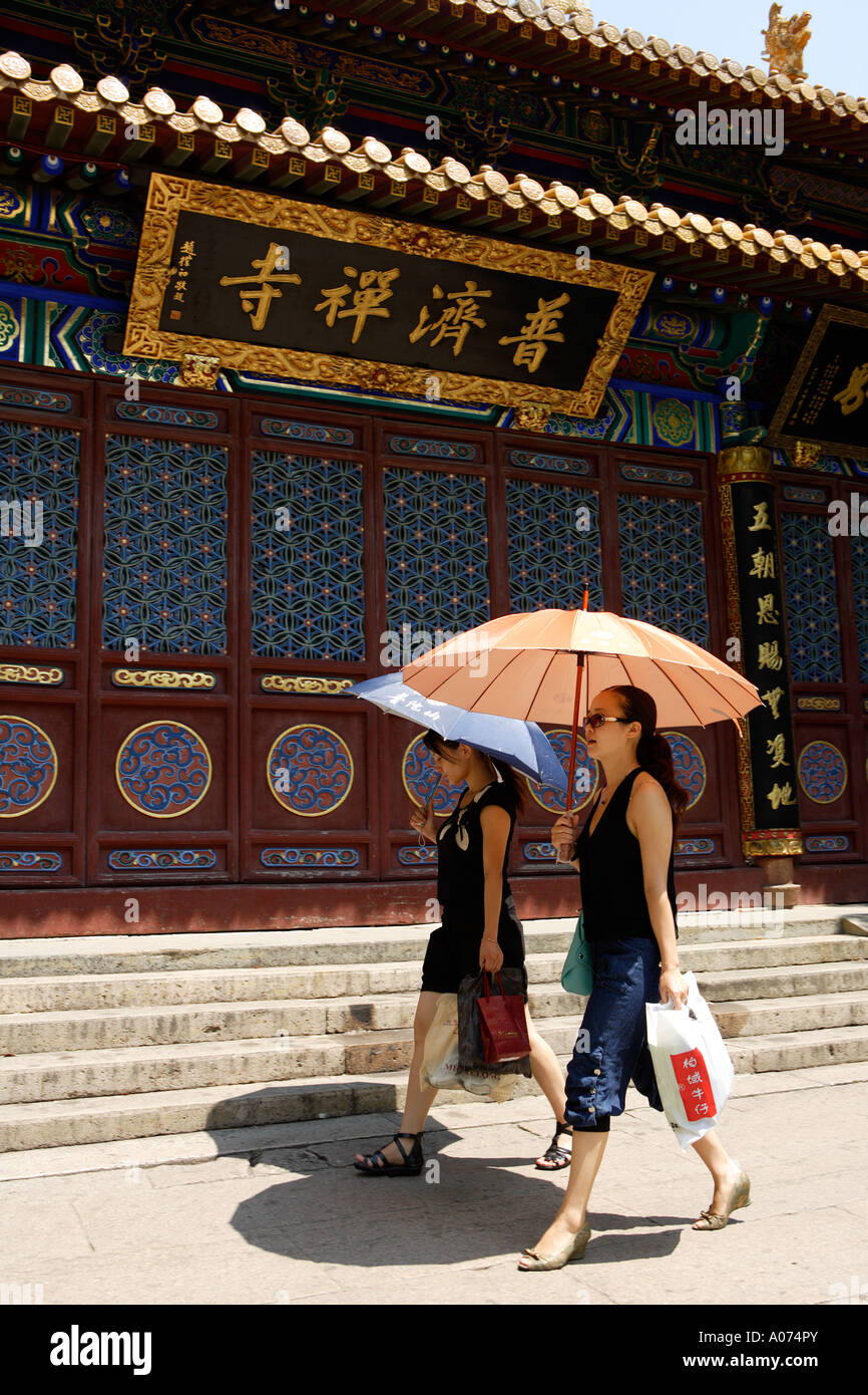 Touristen mit Sonnenschirmen, buddhistische Tempel, Putuoshan, China. Stockfoto