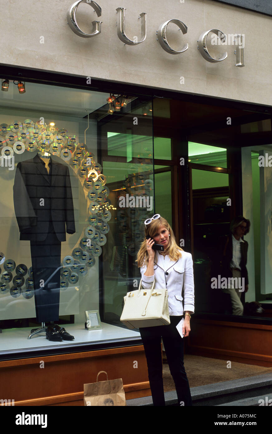 Eine Fasionable Frau reden über ein Handy steht vor einem Gucci-Store in Mailand, Italien. Stockfoto