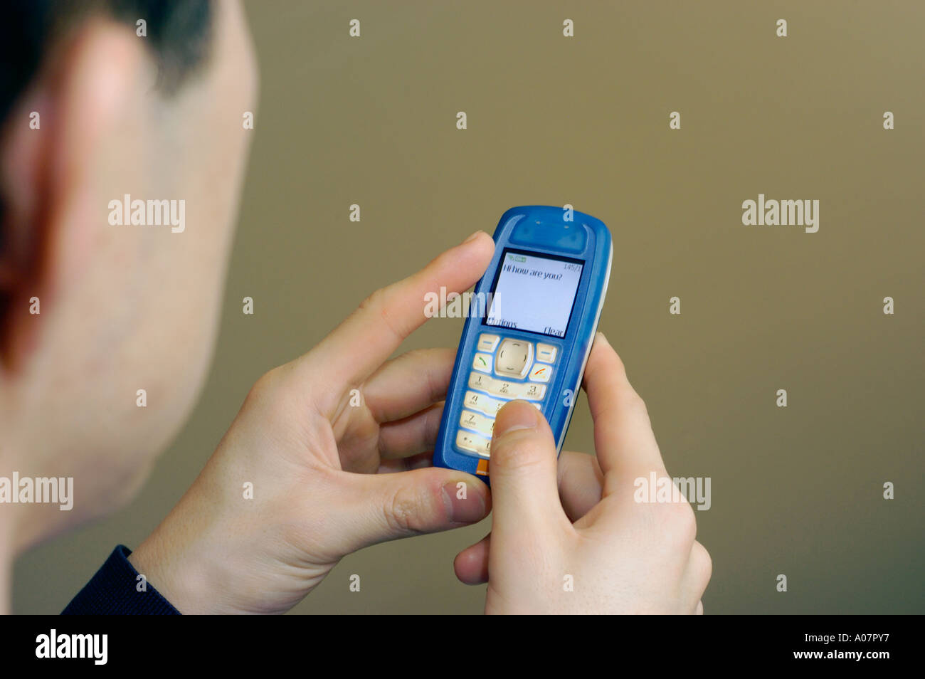 'Young Asian Man' senden 'SMS' mit seinem "Handy" SMS "männliche Hand" Stockfoto