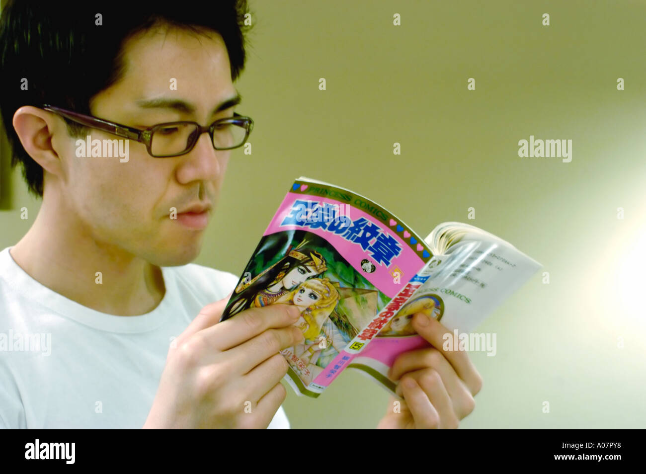 Porträt junger asiatischer Mann Lesung im japanischen Stil-Bildband Buch offen Stockfoto