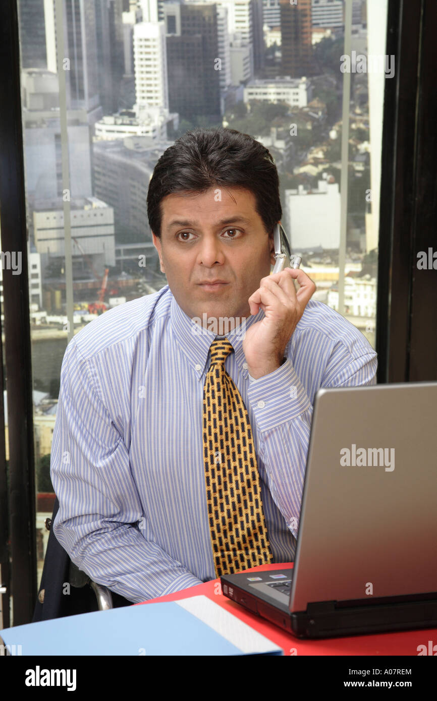 CEO denken arbeiten am Laptop in seiner Kabine mit Stadt-Hintergrund Stockfoto