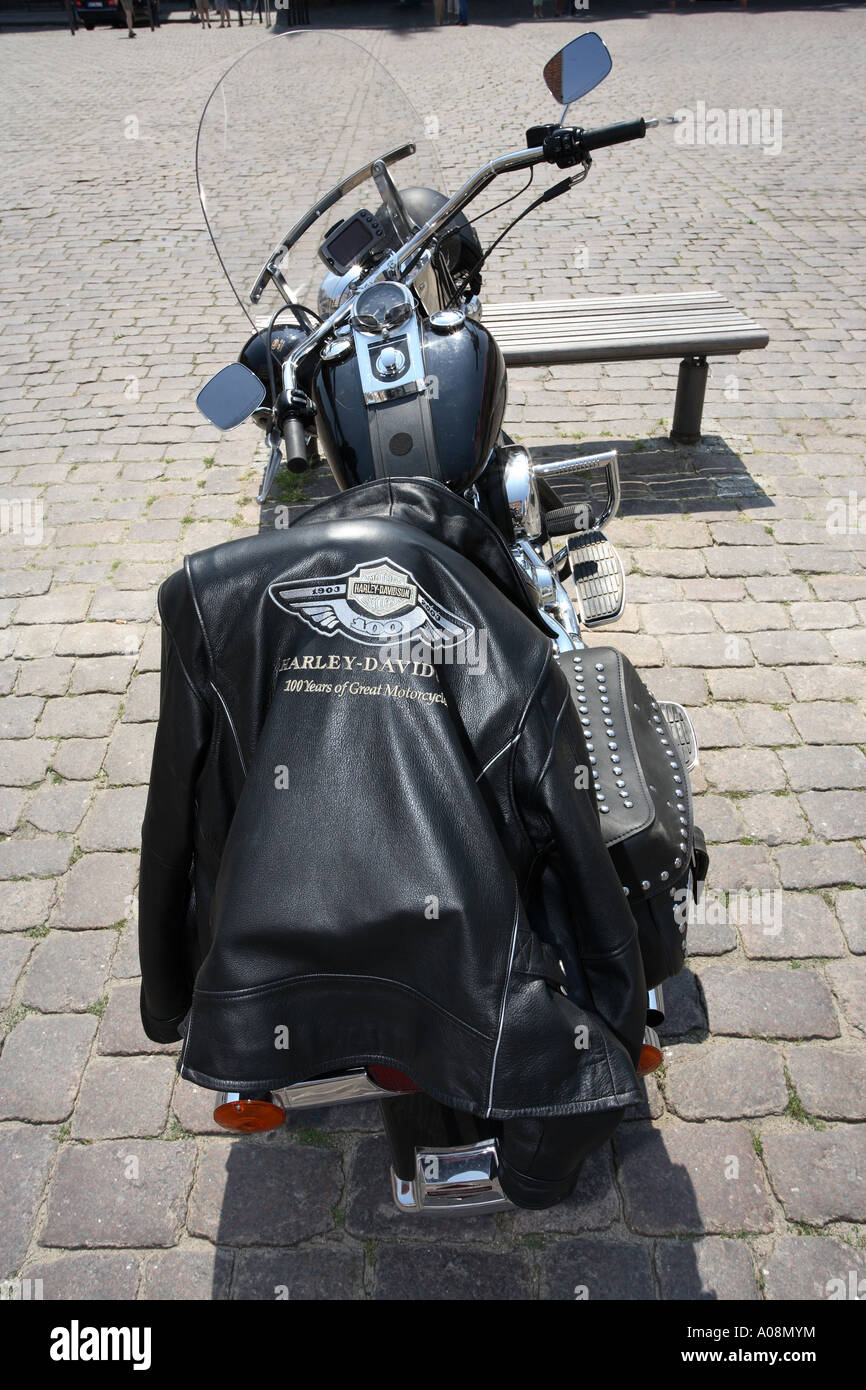 schwarze Lederjacke mit einer Harley Davidson Logo drapiert auf dem Sitz einer Harley Davidson Motorrad Stockfoto