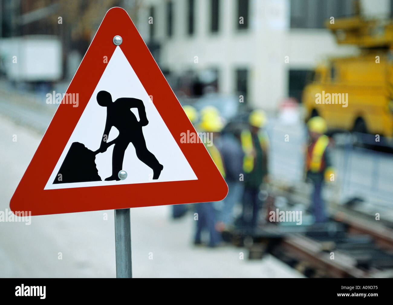 Road ahead Schild mit Straßenarbeiter im Hintergrund arbeiten Stockfoto