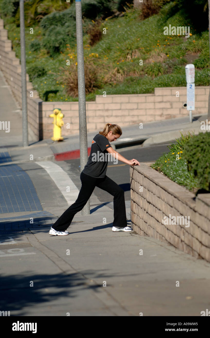 Junge Frau, die Beine gegen Ziegelmauer Joggen jogger Stockfoto