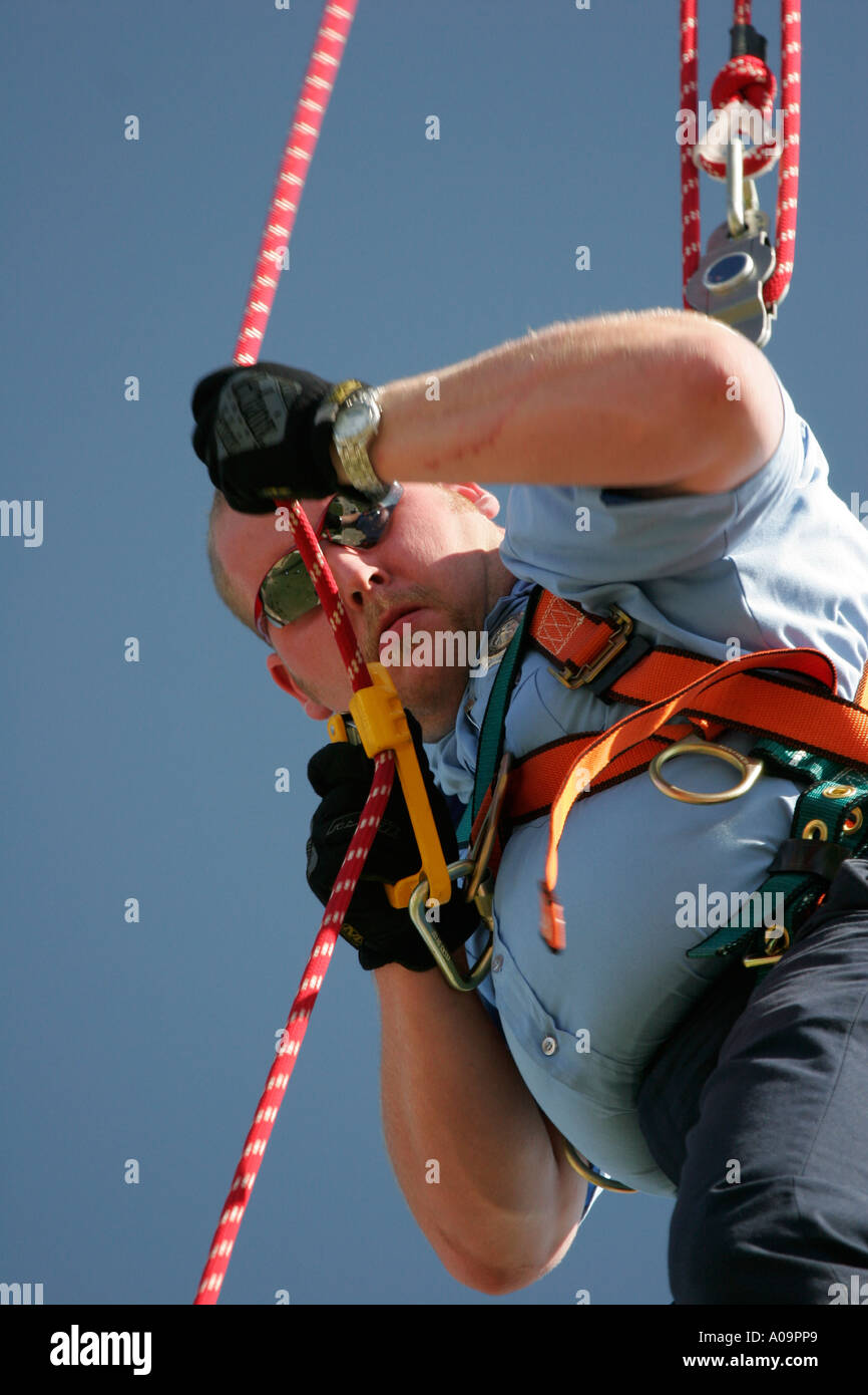 Ein Feuerwehrmann zeigt sein Geschick auf die Antenne Seile Stockfoto
