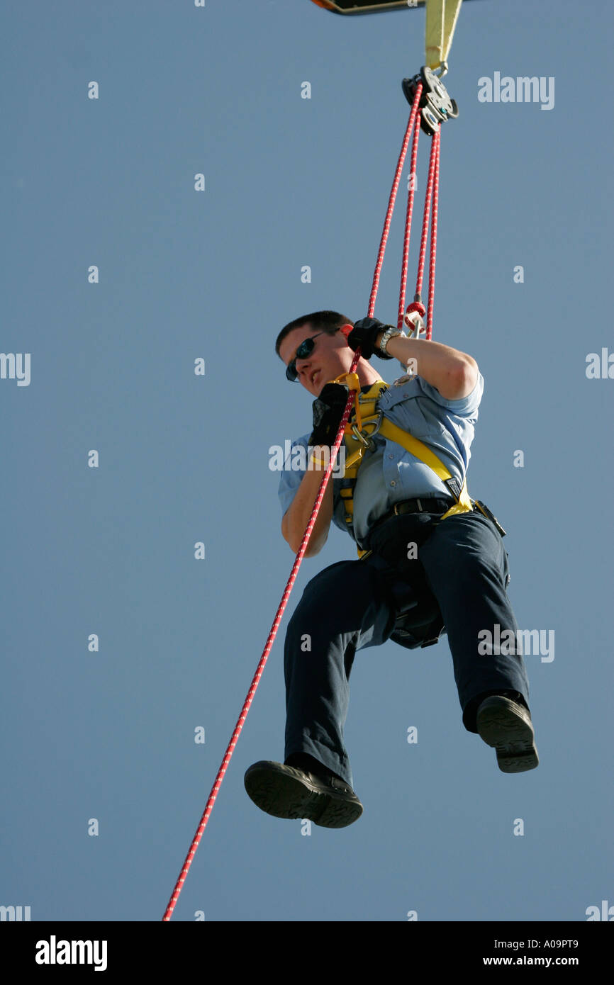 Ein Feuerwehrmann zeigt sein Geschick auf die Antenne Seile Stockfoto