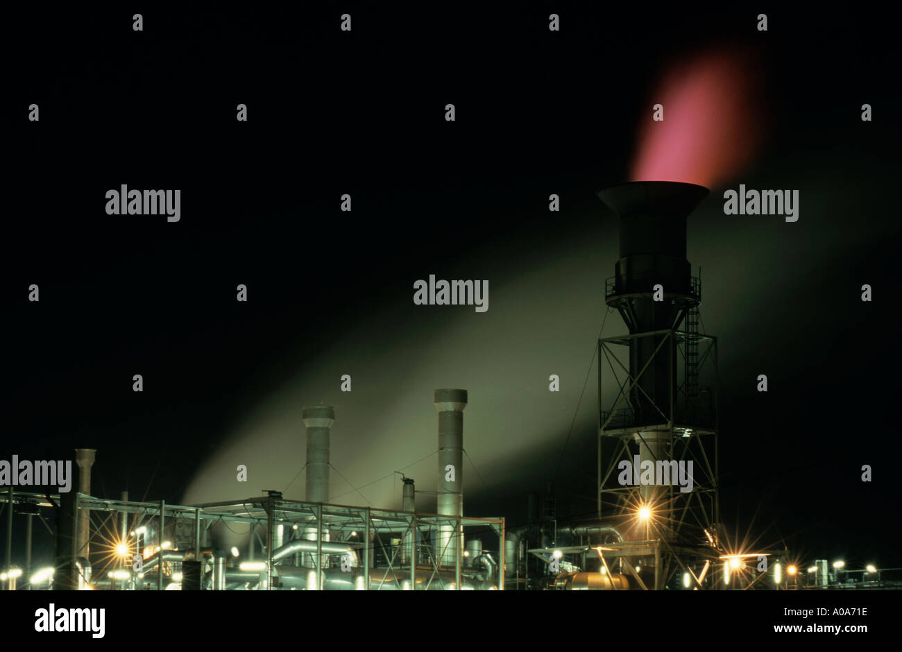 Beleuchtete Schornstein bei einer Erdöl-Öl-Raffinerie in der Nacht Stockfoto