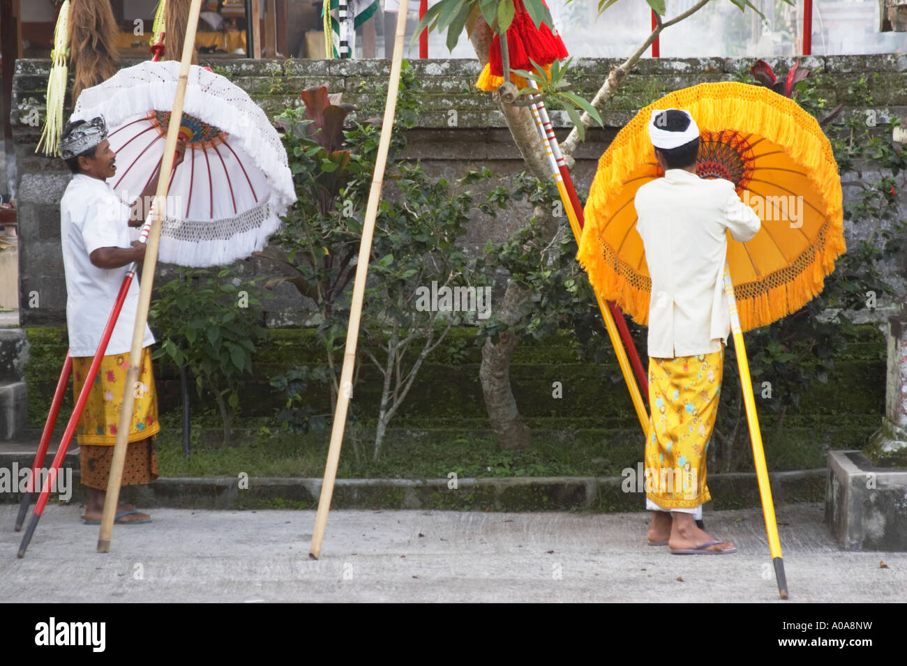 Männer, die das Aufstellen von Sonnenschirmen am Tempel, Ubud Stockfoto