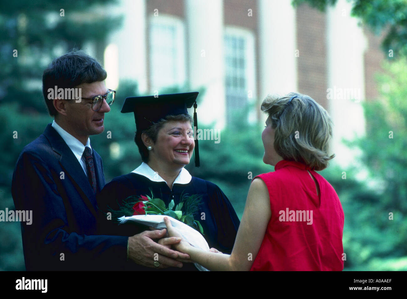 Eine Mutter, die seinem College-Abschluss erhält Glückwünsche von ihre Tochter und ihr Mann Stockfoto