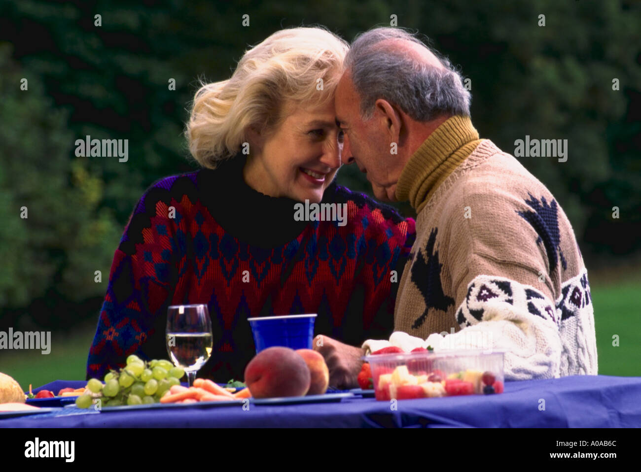 Älteres paar liebevoll betrachten einander beim Picknick im park Stockfoto