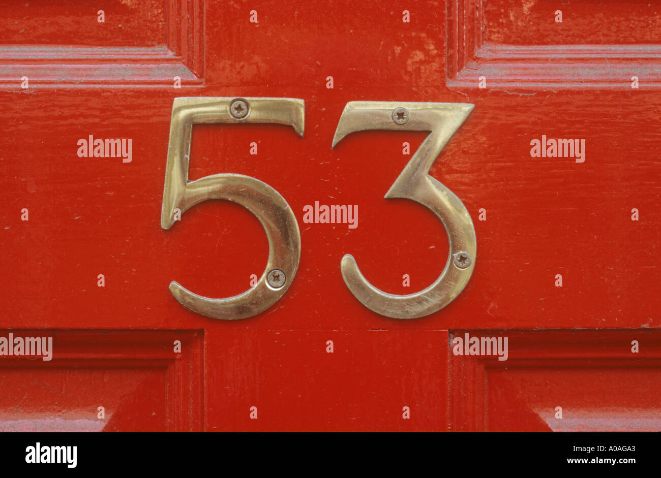 Messing Nr. 53 auf rot bemalte Holztür Stockfoto